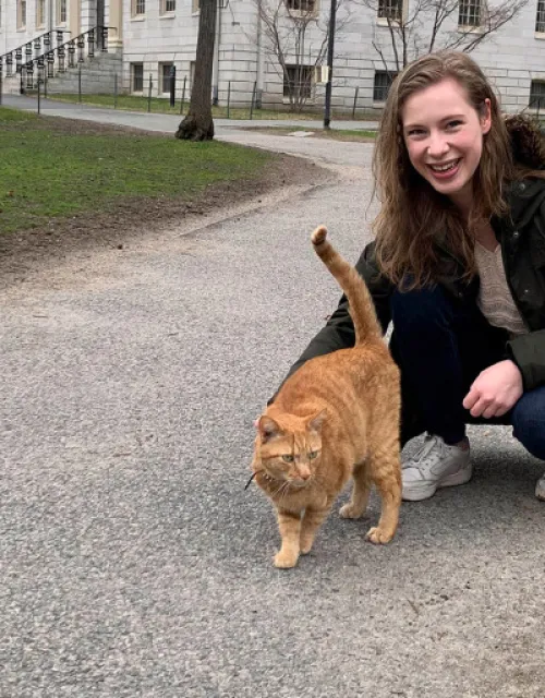 Barbara Oedayrajsingh Varma walks through Harvard Yard with Remy the cat.