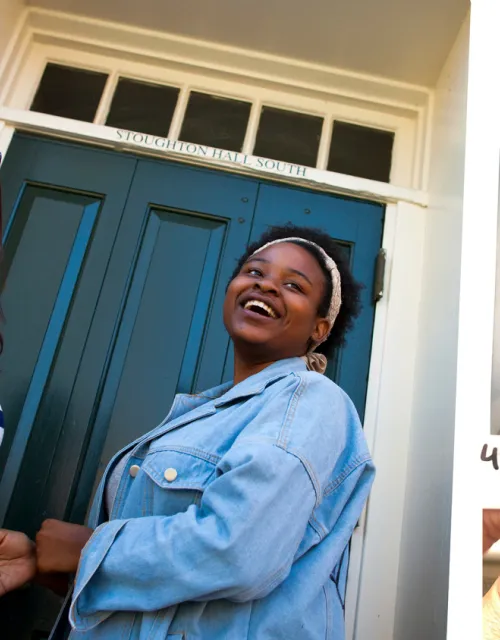 First-year roommates Tatiana Patino (left) and Walburga Khumalo enter Stoughton Hall where they lived in 2017. Four years later, Wal and Tati take one more photo together before moving out. Khumalo made the poster in the background, which is supposed to be a trendier version of the two.