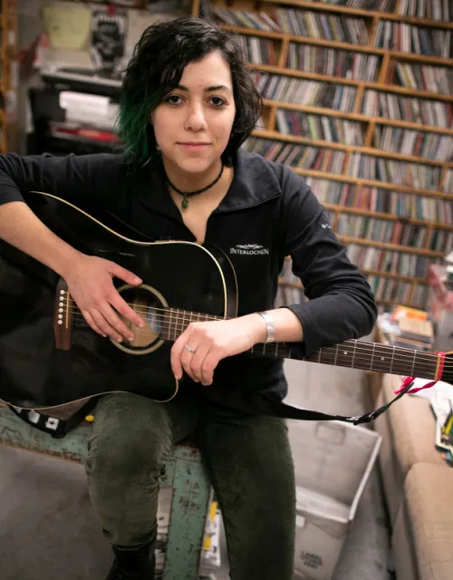 Emily Spector '21 is pictured with her guitar at WHRB, the radio station at Harvard, where Spector is the general manager.