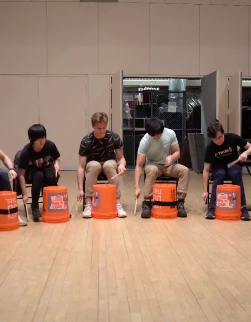 The Harvard Undergraduate Drummers perform a musical number using buckets.