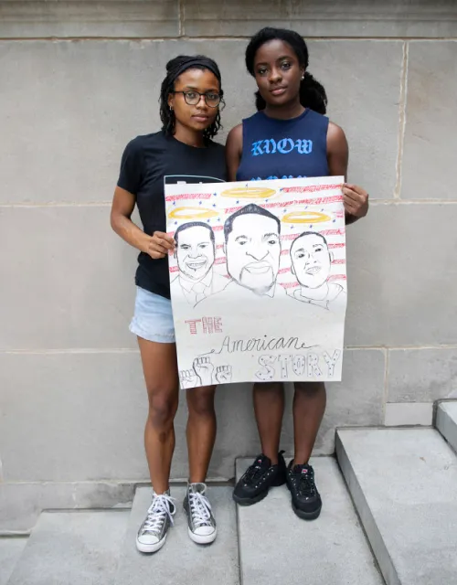 Sisters Cierra Brown ‘23 (left) and Kaelyn Brown '21 hold a sign they made for protests.
