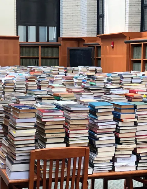 Returns were temporarily stored in the West Stacks Reading Room in Widener Library as they awaited processing by library staff.