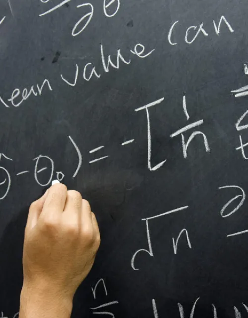 Writing equations on a chalkboard.