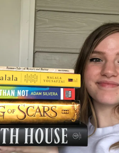 Madi Fabber '22 poses with a stack of novels.