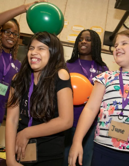 Back in early March, Nina Uzoigwe '21 (left) demonstrated static electricity with a balloon on the head of a student as Kaelyn Brown '21 (back left) and her sister Cierra Brown '23 (back right) looked on. The pandemic forced the club to halt its in-person programming, moving it online.