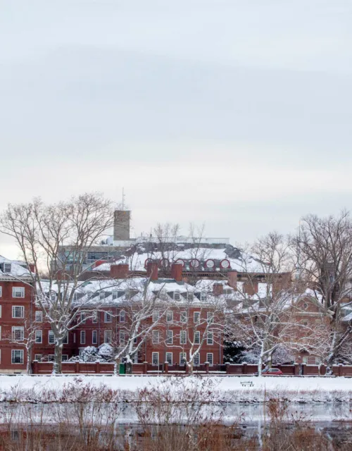 The towers of Eliot and Lowell Houses are pictured along the Charles River after a 2019 winter storm. 