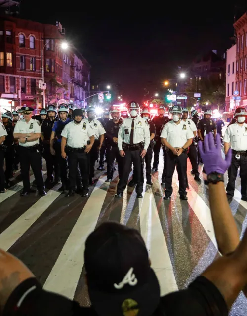 Protesters take a knee in front of New York City police officers during a solidarity rally for George Floyd, June 4, 2020.