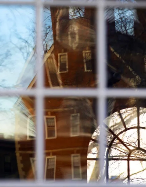 Kirkland House is reflected in the windows of Winthrop House.
