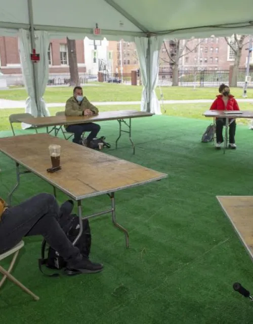 Juan Espinoza, a third-year Harvard Law School student, joins others in a tent in the Yard for English with instructor Sam Marks.