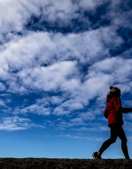 A runner jogs in a field.