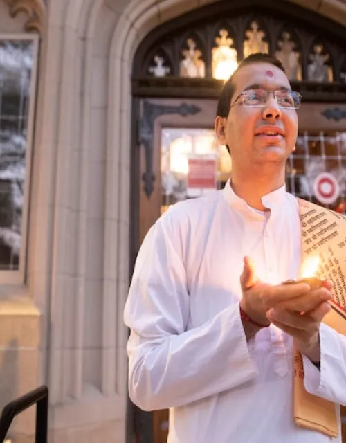 Venerable Vandan Sadhak, a Hindu monastic and Divinity School student, celebrates Diwali at dusk outside Swartz Hall. The festival of lights is celebrated by Hindus, Jains, Sikhs and some Buddhists.