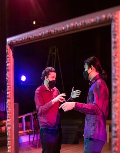 Benjy Wenzelberg (left) directs one of the actors on stage.