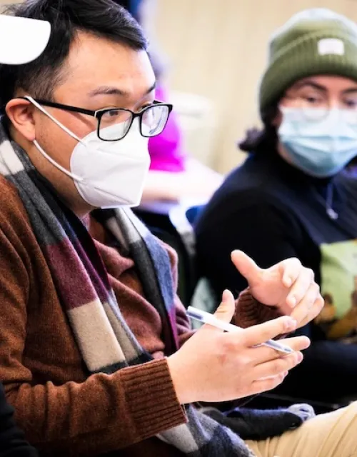 Student Charles Hua (second from left) asks a question in class.