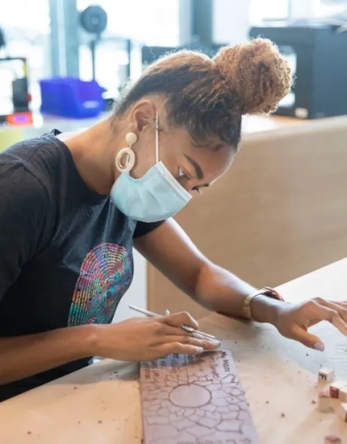 Senior DaLoria Boone personalizes a brick for the "Inclusions" art installation on display in Harvard Yard through May 2.