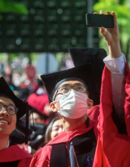 group of seniors in cap and gowns in Harvard yard