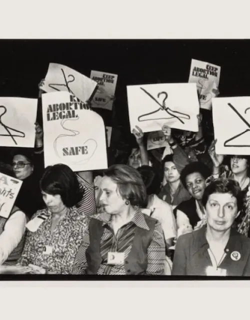 At the International Women's Year conference in Houston in 1977, attendees hold clashing signs on abortion rights.