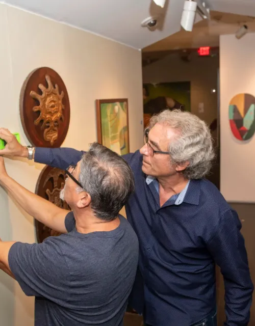 Pablo Gonzalez (left) and Alejandro de la Fuente install “El Pasado Mío / My Own Past,” a new Afro-Cuban art exhibition at the Cooper Gallery.