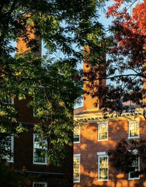 Brick building amidst fall colored trees 