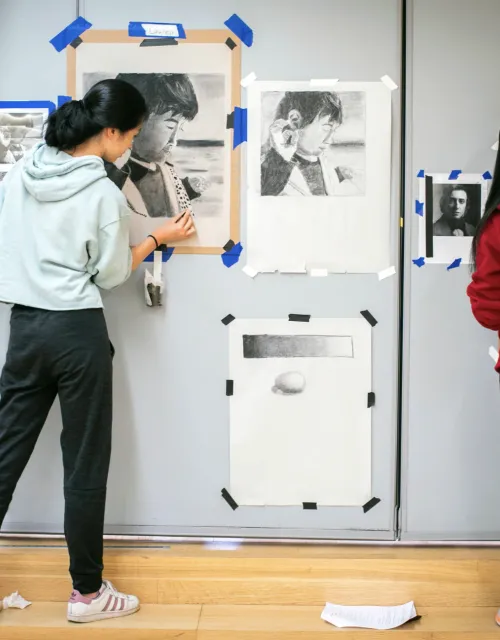 students create a charcoal drawing of someone important to them. Lauren Chen ’24 (left) and Minjue Wu ’22 work on their portraits.
