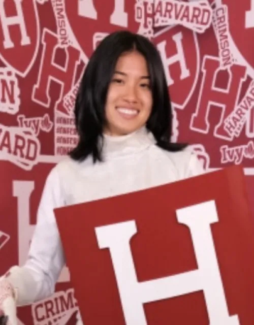 Cynthia Liu posing with Harvard crest in fencing uniform