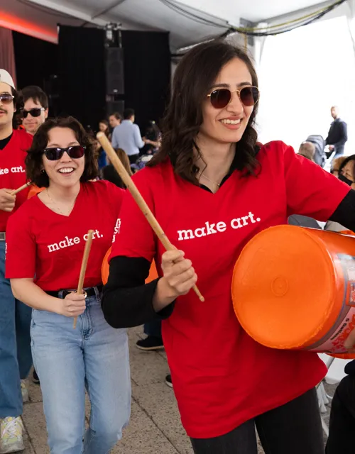 4 Harvard THUD drummers walk down the aisle outside at the science center at Arts First 2022