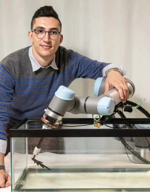 Henry Cerbone standing behind his robotic model of a basilisk lizard’s broad foot