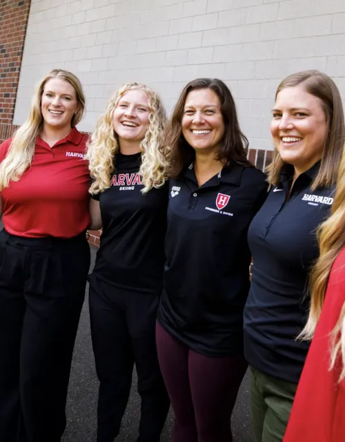 5 women lined up next to each other in front of a building dressed in athletic gear
