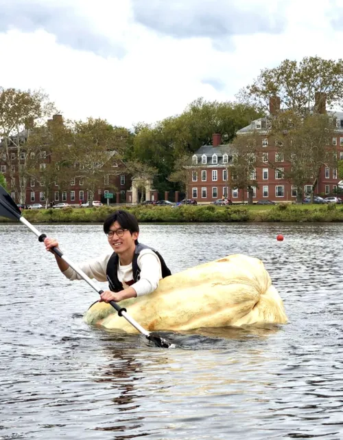 Benjamin Chang rows a hollowed-out 1,500-pound pumpkin across the Charles River.