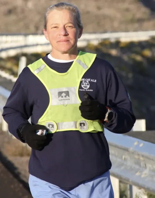 Physics Professor Jenny Hoffman running on the edge of a high way. 