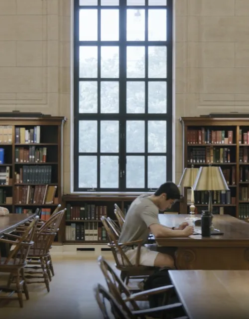 Interior shot of tables in Widener Library with students at desks
