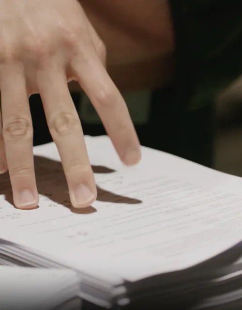 Close up photo of Student picking up packet of papers