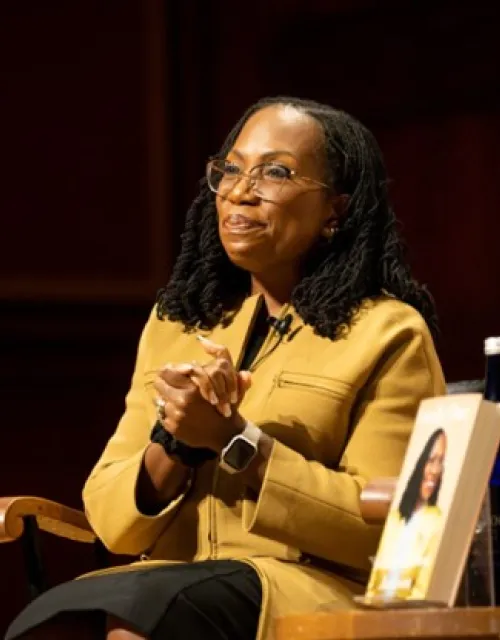 Women sitting in chair clasping hands