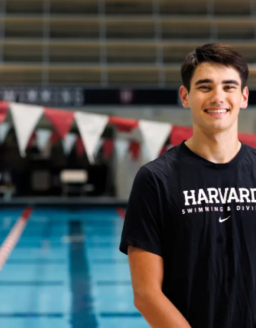 Harvard College Senior Nicola Hensch smiles next to a pool at Harvard's athletic facility.