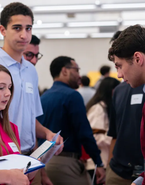  A group of young professionals having a conversation at a busy networking event