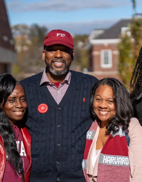 A family of four smiles together for a photo.
