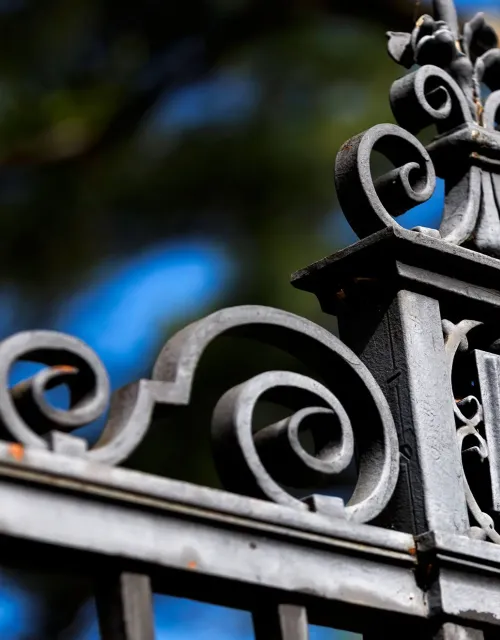 Close-up of an ornate gate with the word "VERITAS" engraved.
