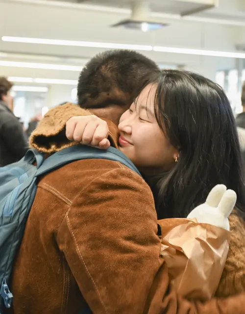 A student hugs her friend to celebrate her graduation.