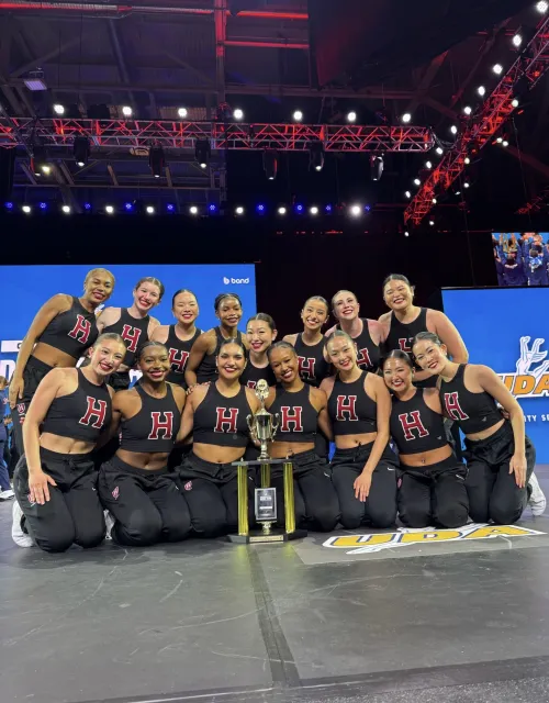 The Dance Team onstage crowded around their trophy.