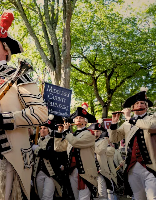 The Middlesex County Volunteers Fifes & Drums leading the group with flutes and drums while dressed in period clothing.