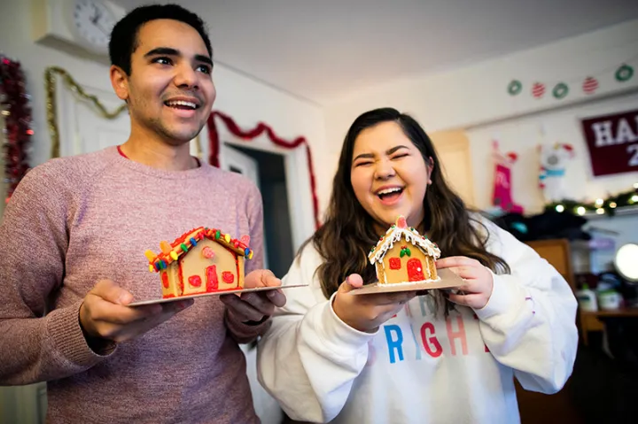 Lena Lofgren '23 and Kyle Felter '23 show off their completed gingerbread houses