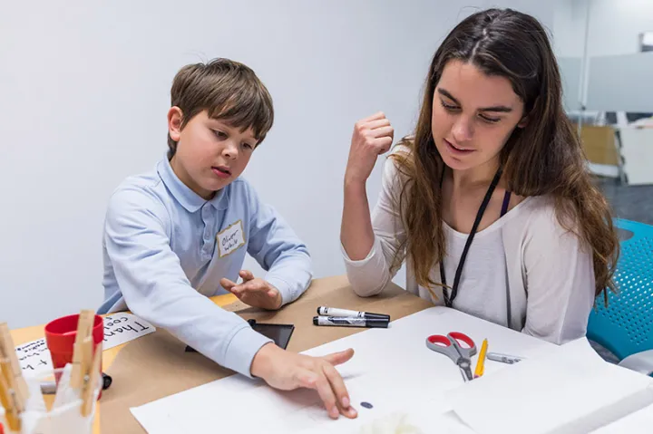 Grace Eysenbach '20, an electrical engineering concentrator, works with mentee Oliver White, 11, as they examine fingerprints on the cupcake box
