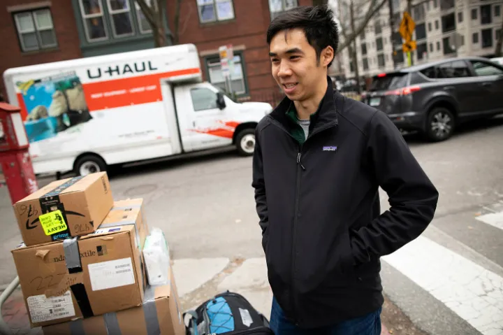 student standing outside with boxes and U Haul moving out of Quincy House