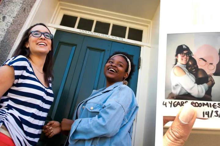 First-year roommates Tatiana Patino (left) and Walburga Khumalo enter Stoughton Hall where they lived in 2017. Four years later, Wal and Tati take one more photo together before moving out. Khumalo made the poster in the background, which is supposed to be a trendier version of the two.