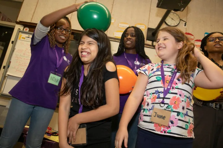 Back in early March, Nina Uzoigwe '21 (left) demonstrated static electricity with a balloon on the head of a student as Kaelyn Brown '21 (back left) and her sister Cierra Brown '23 (back right) looked on. The pandemic forced the club to halt its in-person programming, moving it online.
