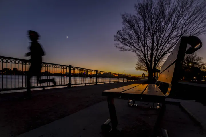 A runner passes the banks of the Charles River near MIT.