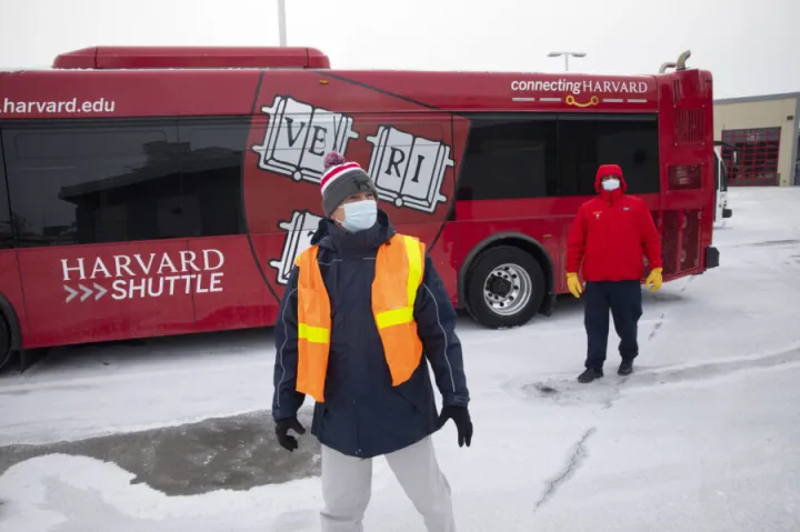 James Monahan (front), associate director of Transit & Fleet Management, and shuttle driver Densis Pena at the Bus Shop in Allston. Harvard will replace four biodiesel buses with 100 percent electric buses this fall.