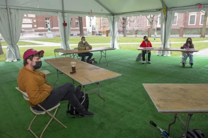 Juan Espinoza, a third-year Harvard Law School student, joins others in a tent in the Yard for English with instructor Sam Marks.