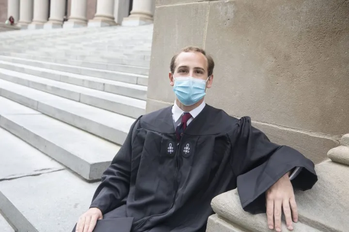 Jordan Bliss Perry '21, who will give the Latin Salutatory, sits on the Widener Library steps.