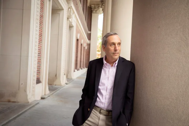 Larry Bacow poses against column at Widener Library 