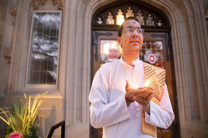 Venerable Vandan Sadhak, a Hindu monastic and Divinity School student, celebrates Diwali at dusk outside Swartz Hall. The festival of lights is celebrated by Hindus, Jains, Sikhs and some Buddhists.